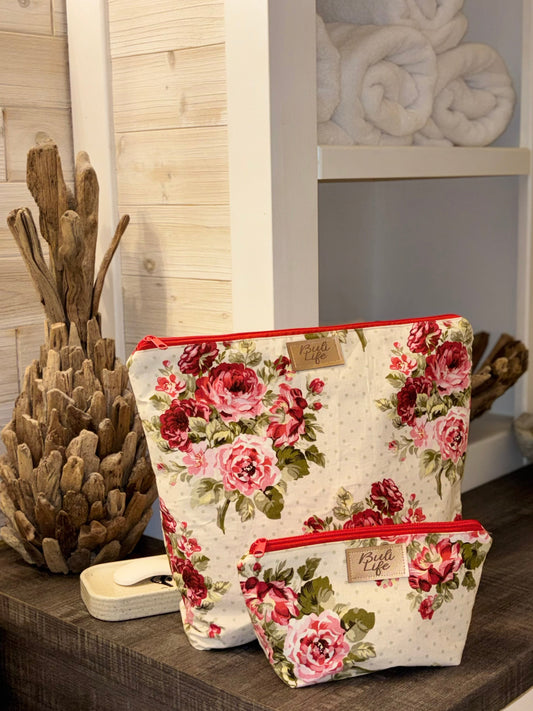 Floral-patterned bags on a wooden surface with decorative items in the background